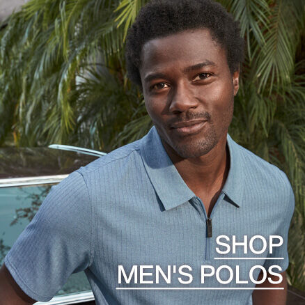 A closeup image of a man wearing a light blue quarter-zip polo with green palm trees in the background. The words Shop Men's Polos read across the bottom right side of the image. 